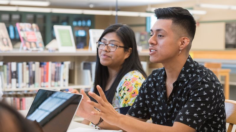 Two undergraduate students speaking with an advisor