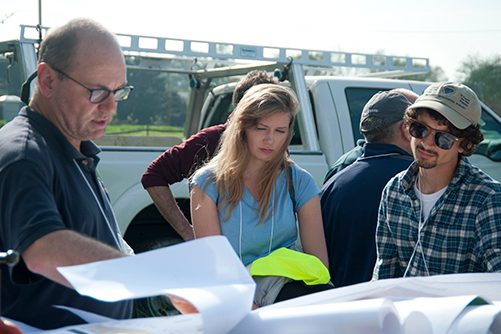 DGS staff examine survey plans near a drill site