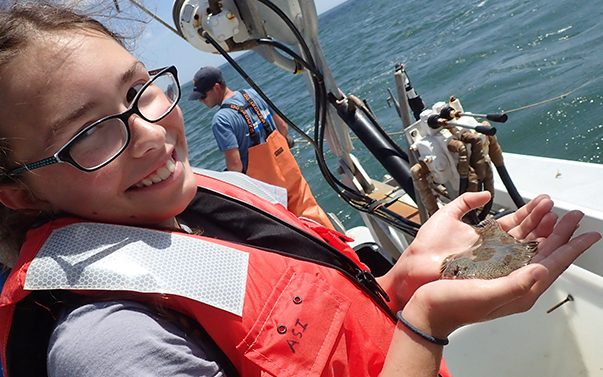 Student in TIDE camp holding sea animal