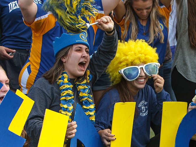 Students cheering in crowd during football game