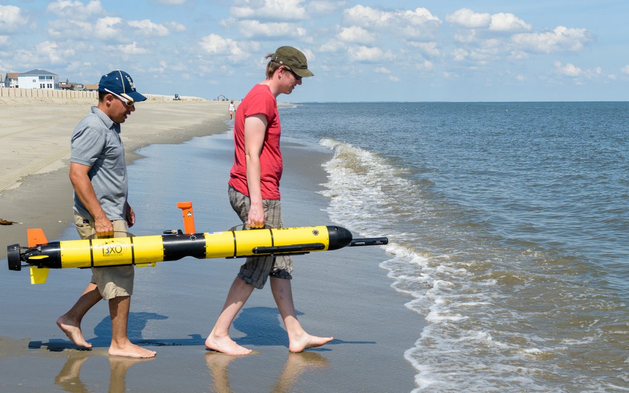 Students carrying an AUV on Lewes beach