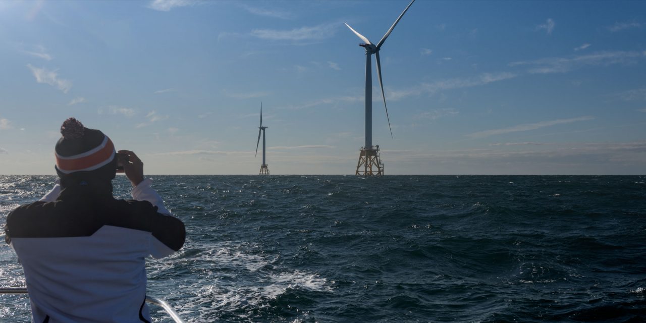 Student observing offshore wind turbine