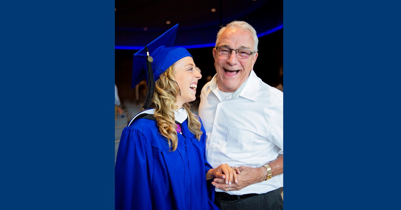 Mike Janis poses with one of the Speech Pathologist graduate students at her graduation