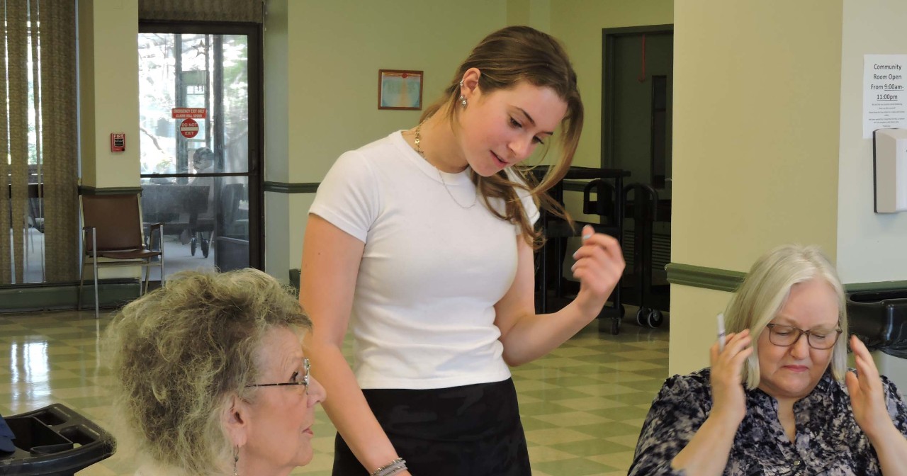 Female student helps senior citizens with bingo 