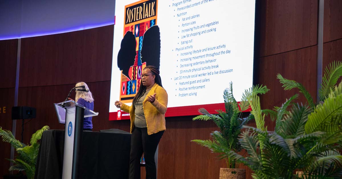 NiCole Keith standing on stage presenting a speech 