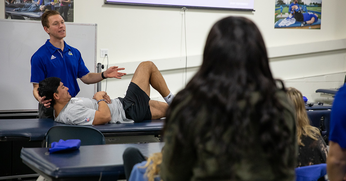 An athlete stretches in a lower extremity spine class for students in the athletic training education program. 