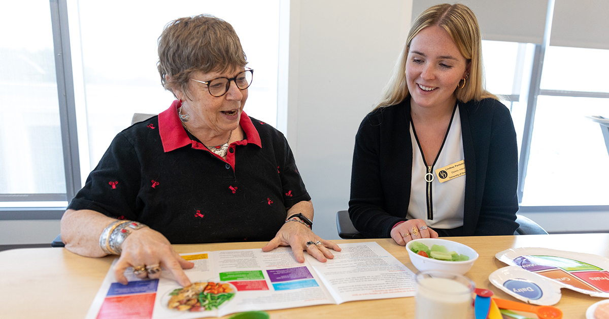 Dietetic intern Lindsey Paniszczyn works with Prevent T2 program participant Susan Riedy on healthy eating strategies as they review CDC curriculum “Eating Well to Prevent T2.”