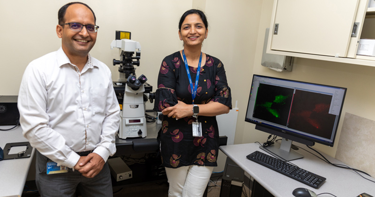 Researchers in UD's Department of Medical and Molecular Sciences pose for a photo in their lab with a microscope behind them. The computer screen shows their study of RNA transport as they seek to understand how cells communicate. 