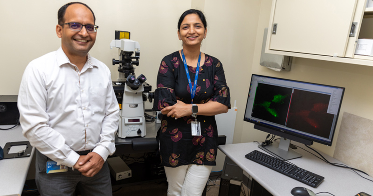 Researchers in UD's Department of Medical and Molecular Sciences pose for a photo in their lab with a microscope behind them. The computer screen shows their study of RNA transport as they seek to understand how cells communicate.