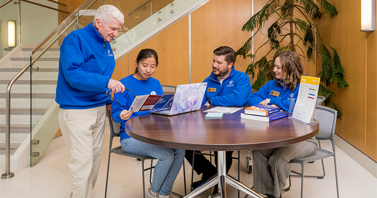 Center for Health Profession Studies staff gather around a circular table to advise a student on the journey to medical school in the STAR building.