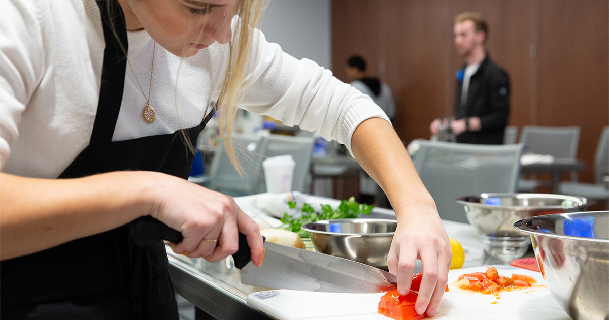 A student chops a tomato.