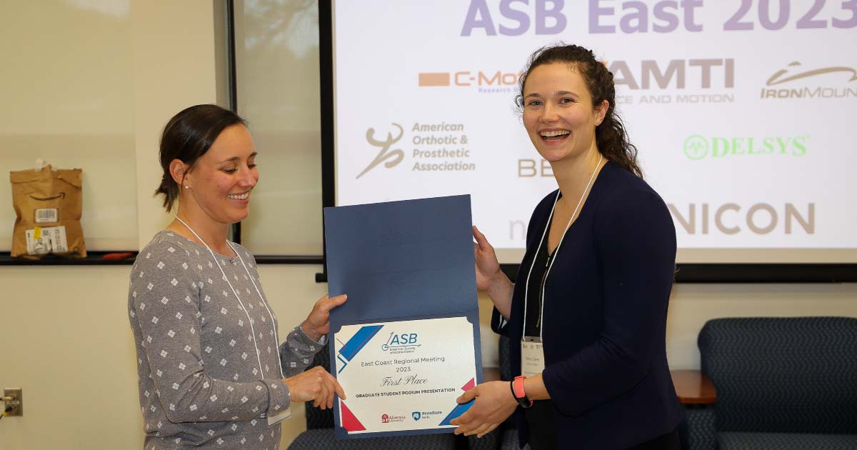 Web Two women smiling holding an award