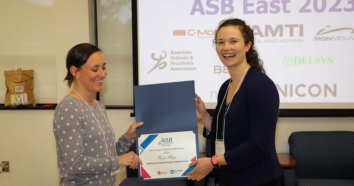 Two women smiling holding an award