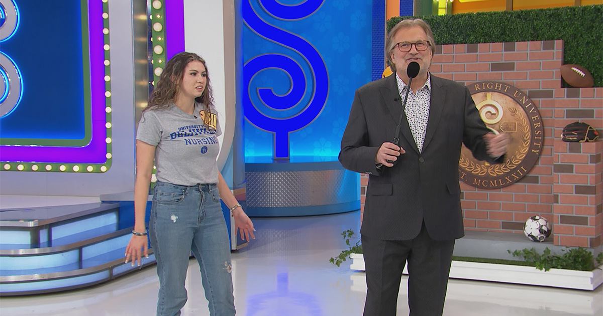 Lily Ramos stands alongside Price is Right host Drew Carey, wearing a gray UD School of Nursing T-shirt after she made it on stage for a special college edition of the popular TV game show.