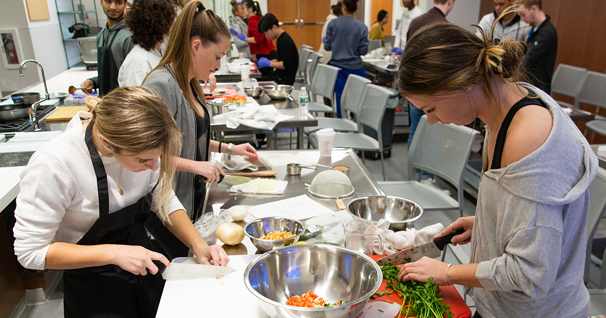 Students chop veggies in a cooking class with Jennifer Muzzi in the demo kitchen in the Tower at STAR. 