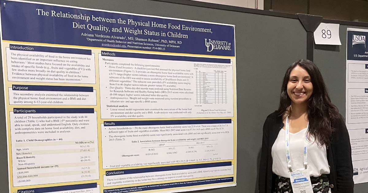 Woman standing in front of poster presenting her research on diet in children
