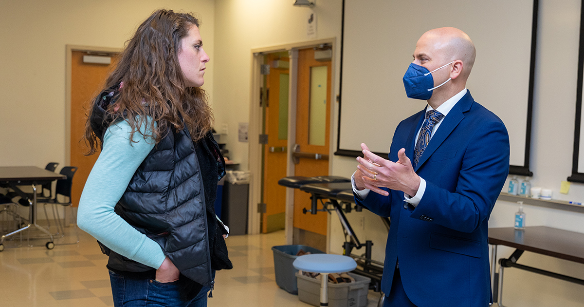 Highmark president Nick Moriello talks with his hands to biomechanics and movement science doctoral candidate Kiersten McCartney after class in the Health Sciences Complex.