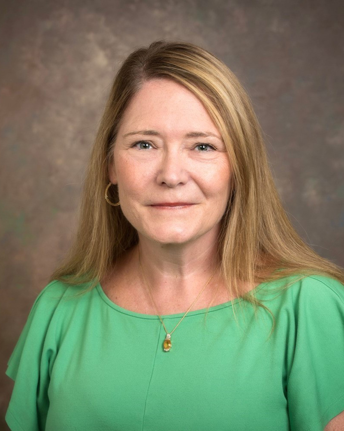 A headshot of Tara Pezzuto. She's wearing a green short-sleeved shirt.