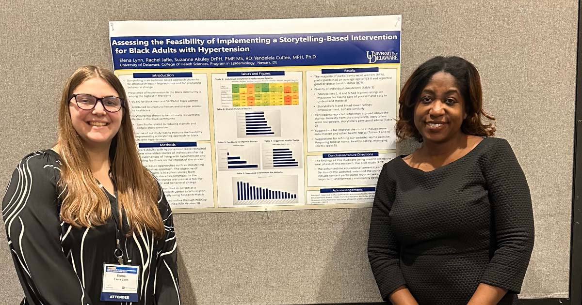 Two women standing in front of research presentation