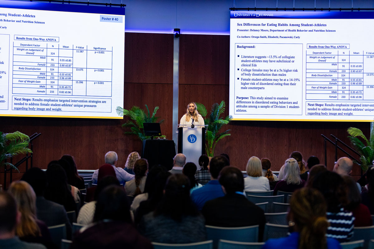 Delaney Moore, who's getting her master's in health promotion, gives her 60-second podium pitch on her research into eating disorders and disordered eating among student-athletes on the stage in the Audion.