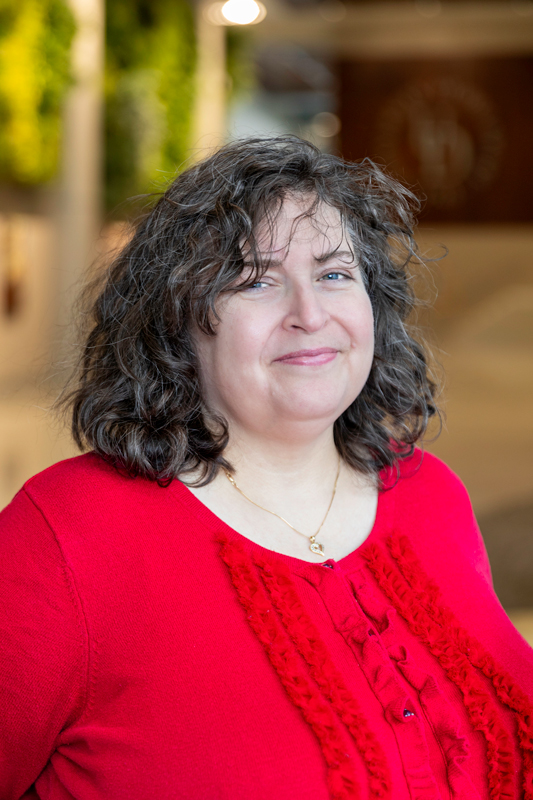 Headshot of Nicole Pekarek wearing a red shirt with a ruffle, taken in the STAR Tower lobby.