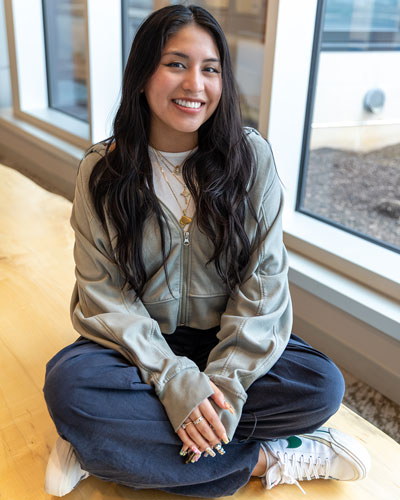 Senior health behavior science major Leslie Loja sits with her legs crossed on a bench in the Atrium of the STAR Tower.