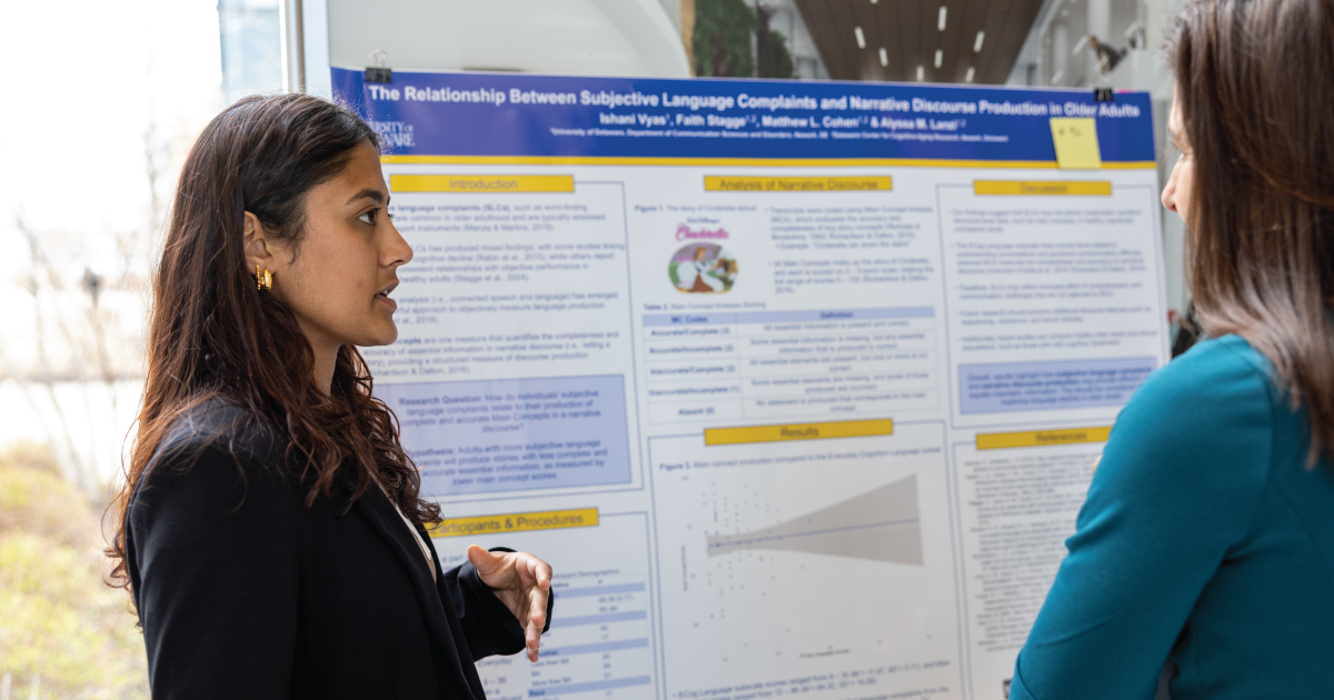 An image of a woman standing by her research poster