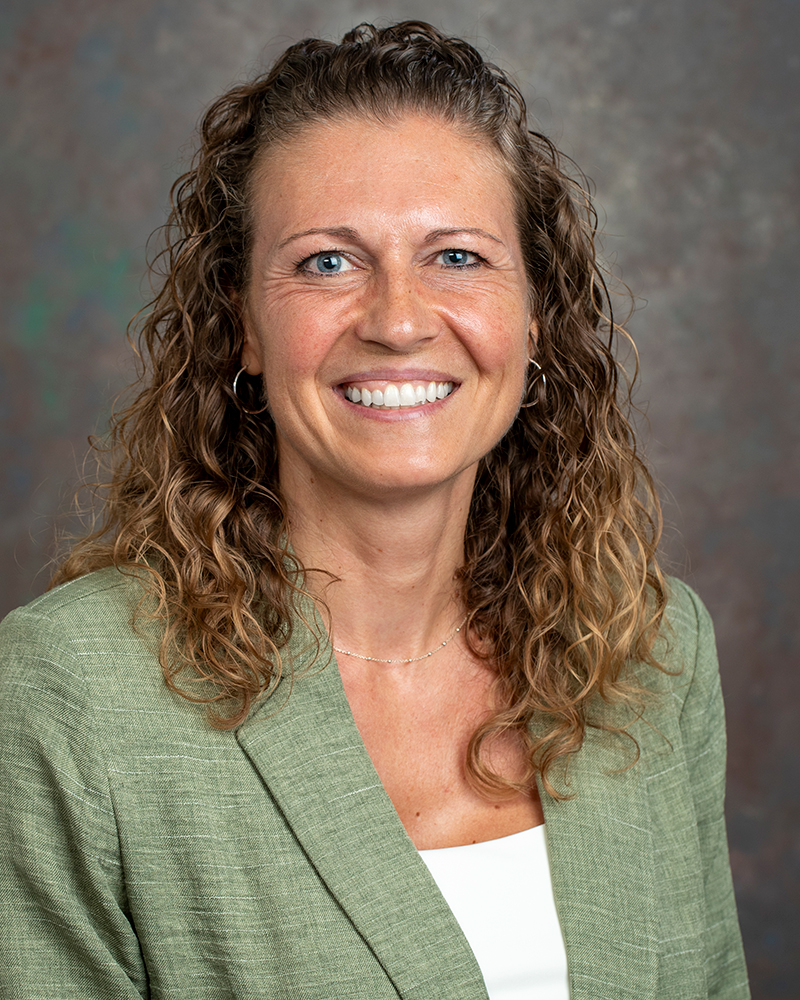 A headshot of new MMSC Assistant Professof Jessica Bless wearing a light green blazer and a white shirt.