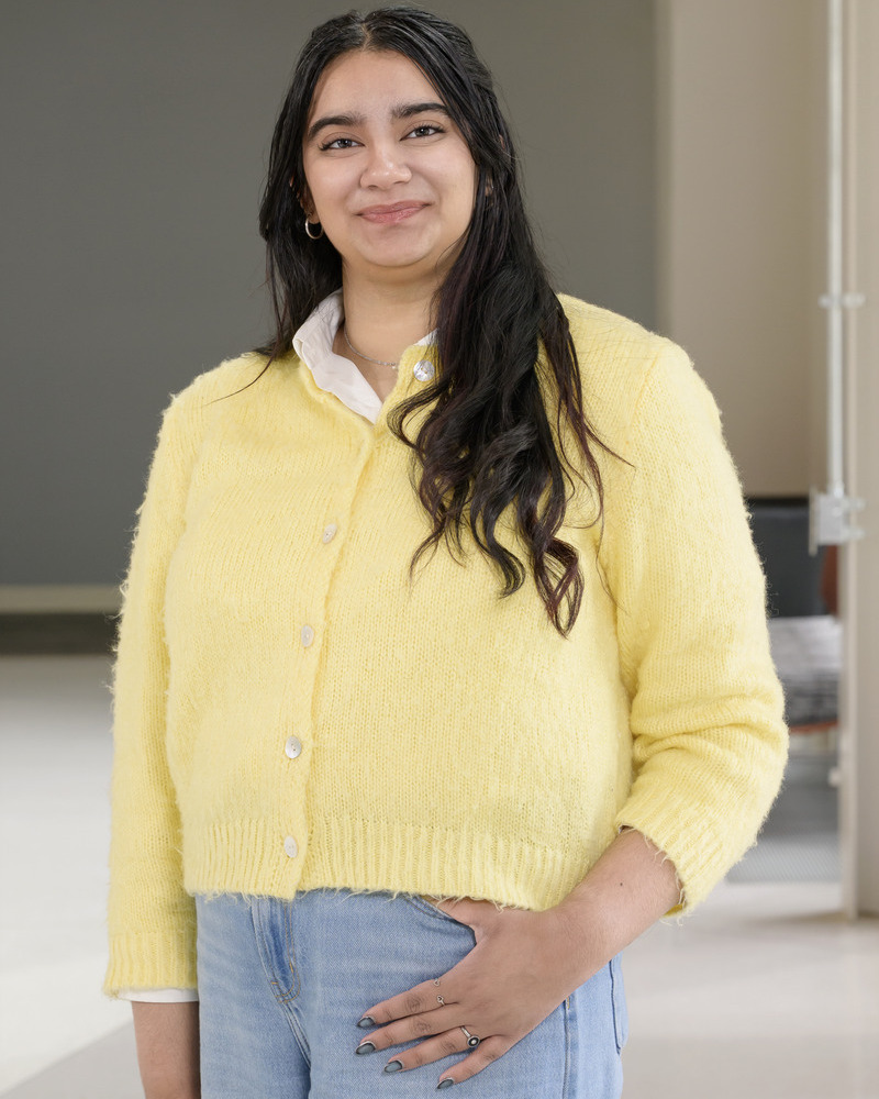 A headshot of senior nutrition and medical sciences major Arshia Singh wearing a yellow button-down sweather with a white collar popping out. 