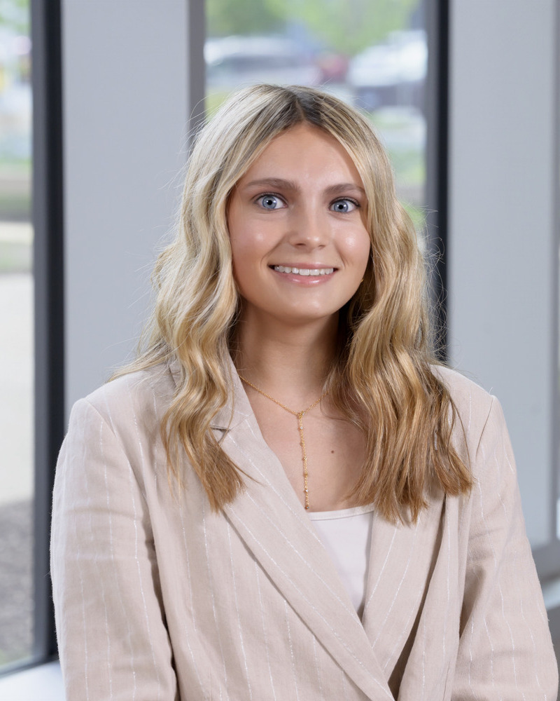 A headshot of Carlie Chylack, a senior nutrition and dietics major, is seated wearing a beige blazer.