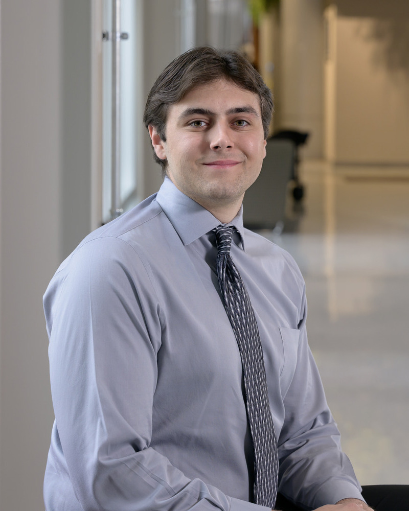 A headshot of Ryan Hoefer, a senior human physiology major, seated wearing a blue shirt and tie. 