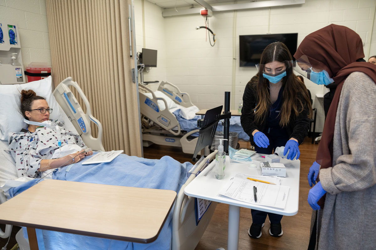 Graduate students working with a patient.