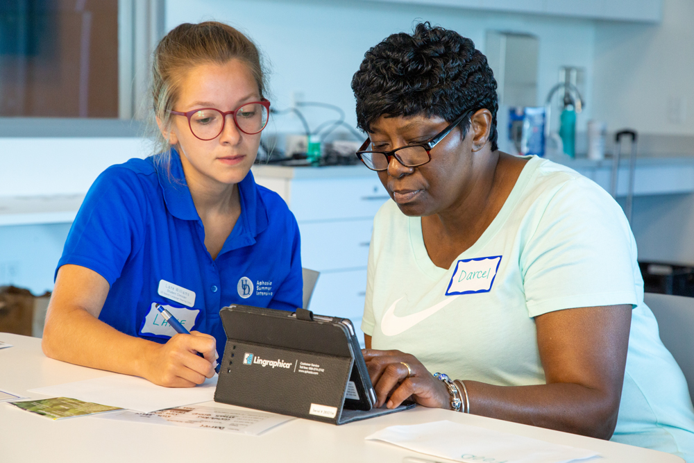 Speech Language Pathologist Master's student pointing at a tablet while in a session with a patient
