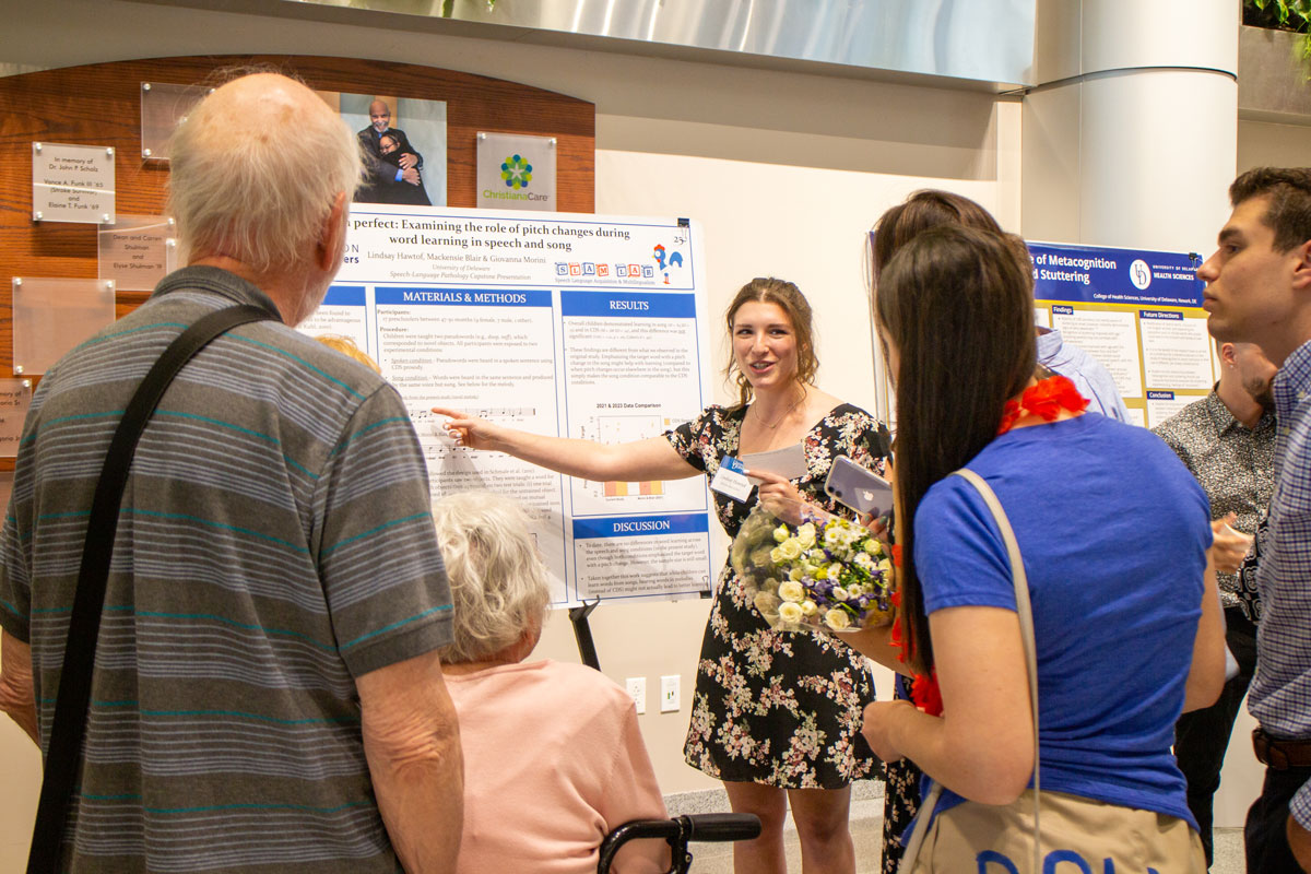 Student giving a presentation to attendees of a related conference.