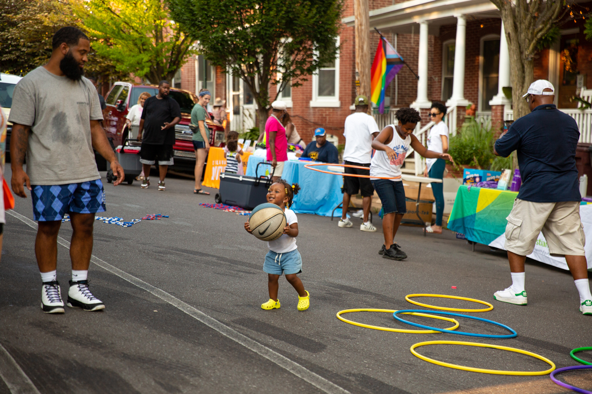 Adults and children playing in the street during a community event