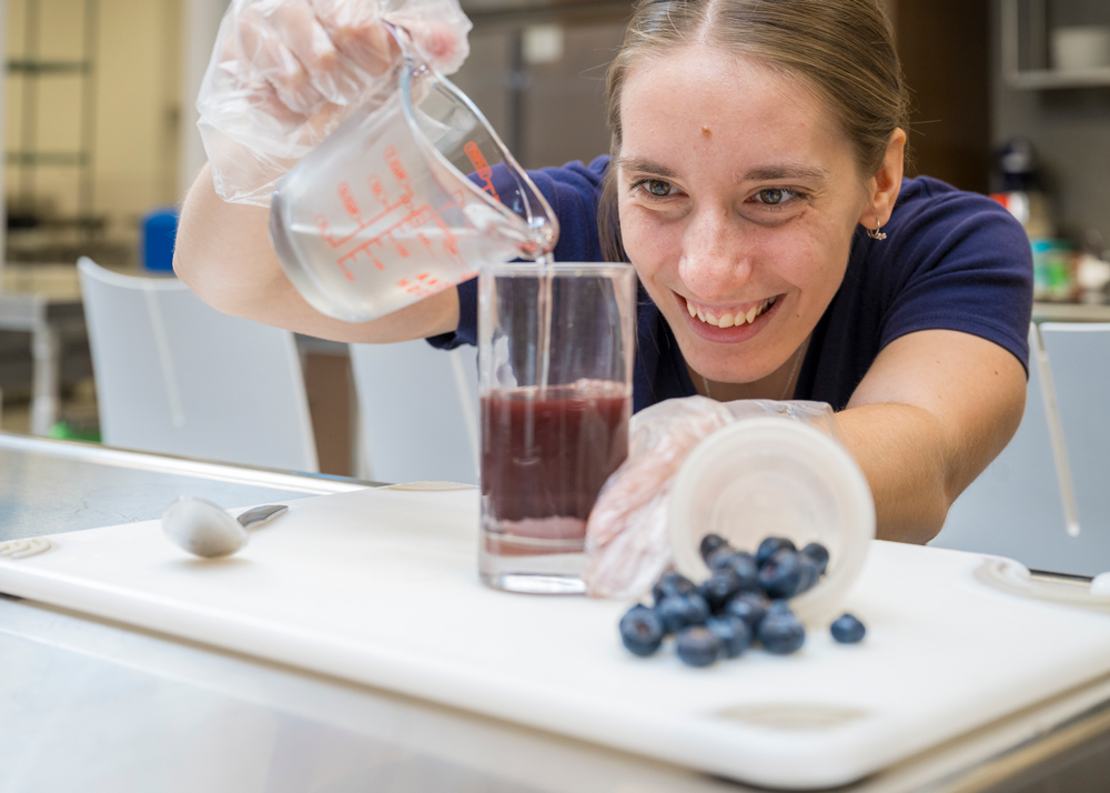Nutrition student creating a blueberry supplement drink for a research study