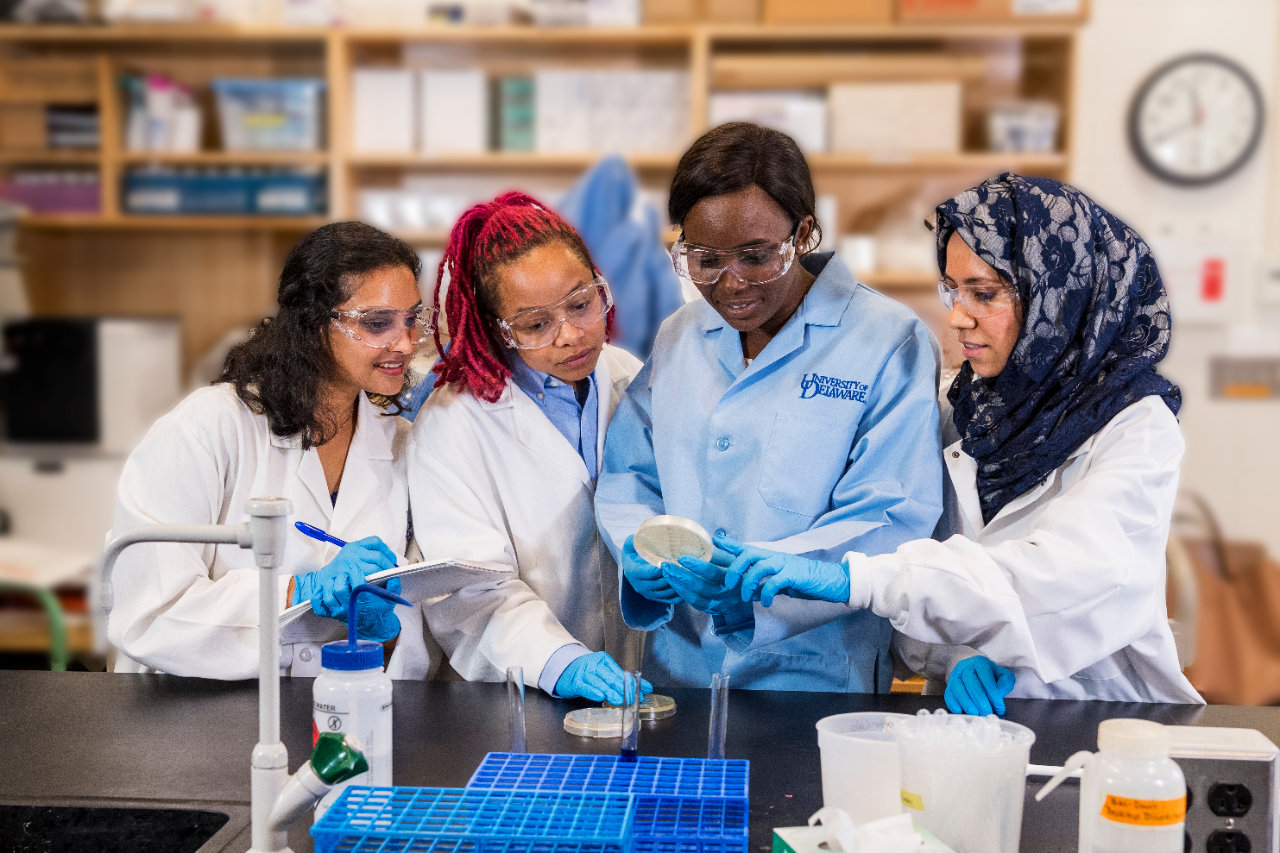 Four female students in lab coats in the lab
