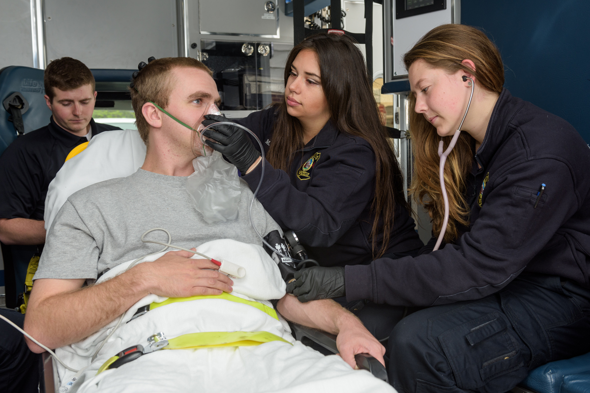 Three EMTS/Paramedics helping a patient