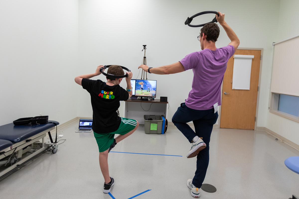 Reed Rigney, a 10-year-old with autism, plays Nintendo with Jacob Corey, Doctor of Physical Therapy