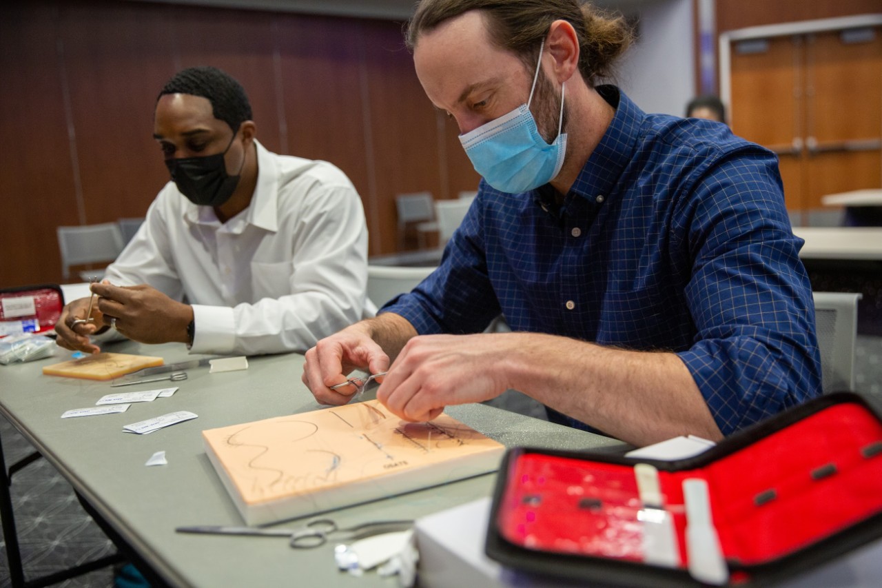Nursing graduate students participate in a healthcare theatre simulation in the Nurse Managed Primary Care Center and practice suturing. 