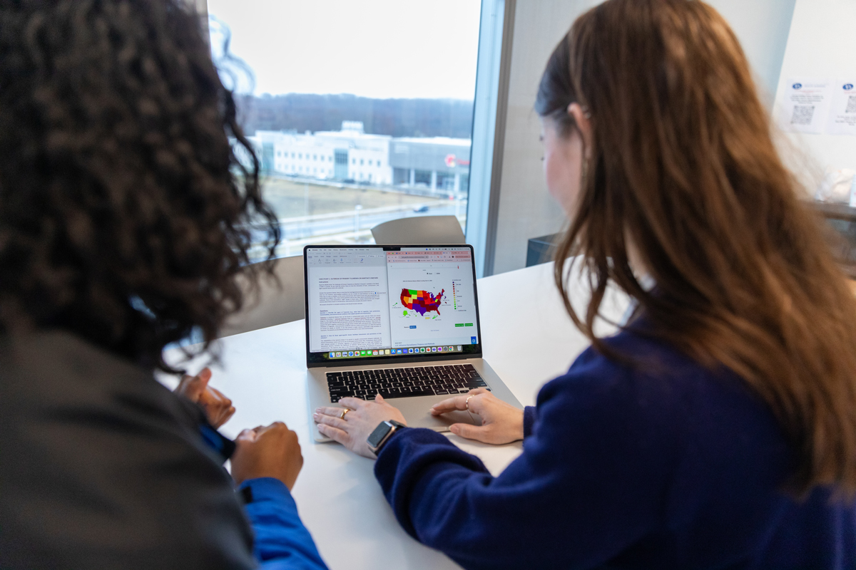 Classroom photo of two students working on a laptop