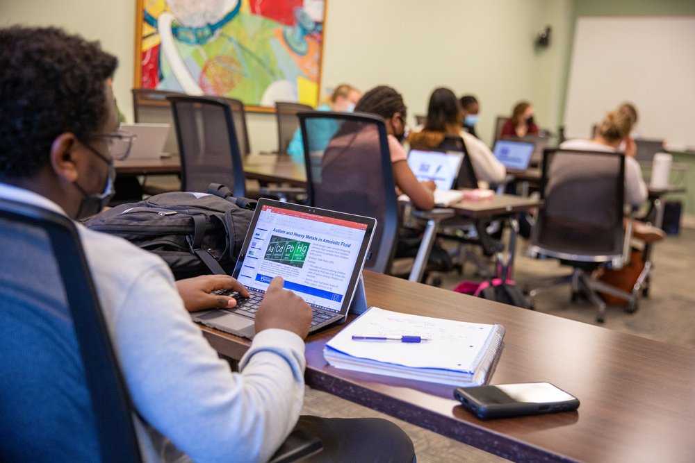 Photo of students in class taking notes on their computers