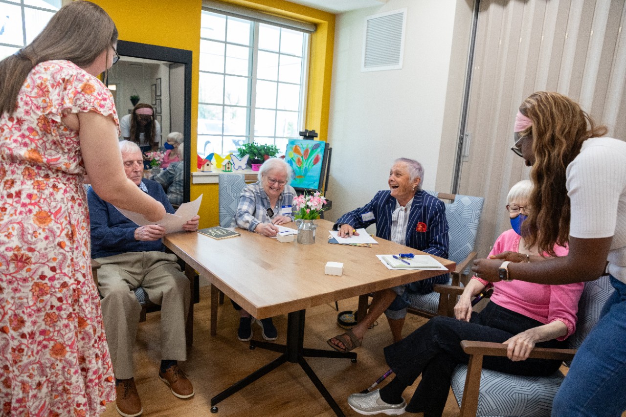 Students interacting with individuals at a memory care facility