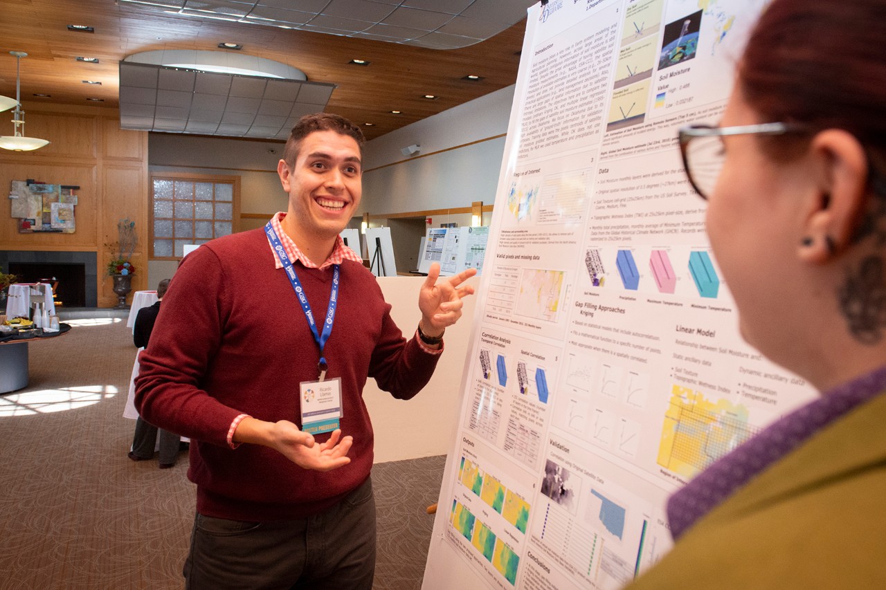 Graduate Student presenting their research in a poster session.