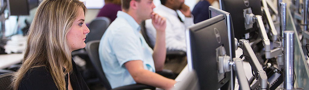 A graduate student in the Business Analytics program looks at monitor during class.
