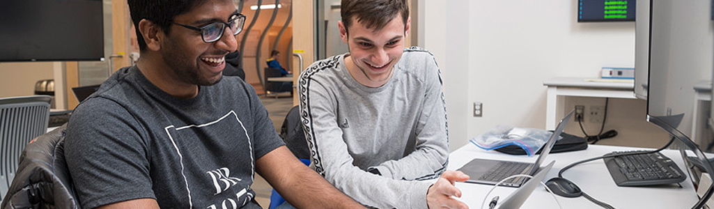 Students developing and practicing cybersecurity skills to make them more “ethical” hackers in the world of cybersecurity in the iSuite at Evans Hall.