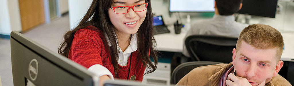 Finance Certificate Business students in discussion as they view something on a computer.