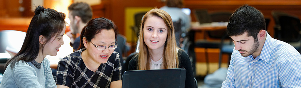 Hospitality business analytics students working together while seated at a table.