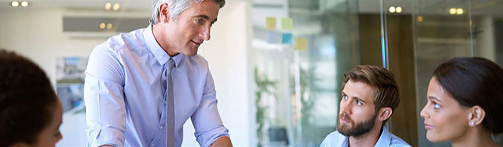 Two business men and women have a discussion in a conference room.