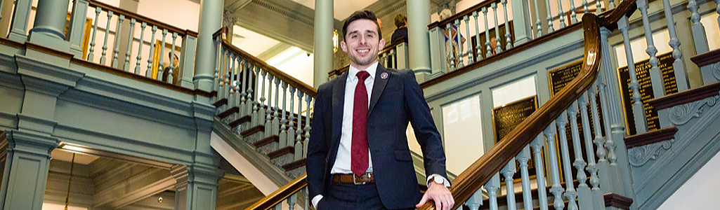 Public Administration student standing on the staircase at Legislative Hall in Dover, Delaware.